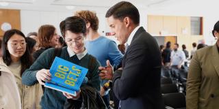 Dr. Rajiv Shah signs a copy of his book, Big Bets, at a Columbia SIPA event on October 10, 2023