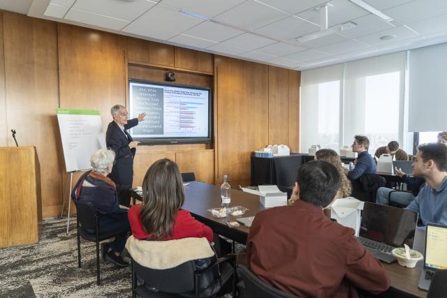 Bruce Stokes presents polling data to students during a working roundtable